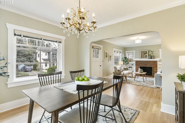 dining area featuring a wealth of natural light, arched walkways, and light wood-style flooring