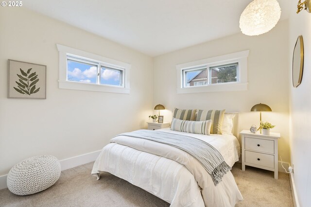 bedroom with baseboards, multiple windows, and light colored carpet