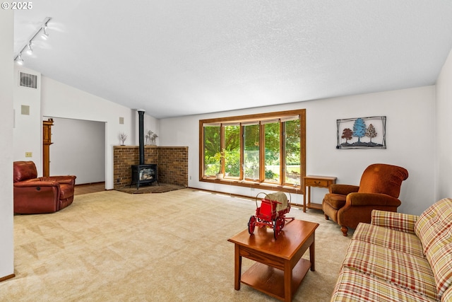 38383 Cartwright Creek Rd, Marcola, OR 97454 - living area with a wood stove, track lighting, carpet, and vaulted ceiling