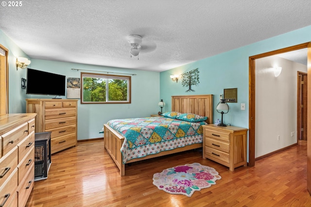 38383 Cartwright Creek Rd, Marcola, OR 97454 - bedroom featuring light wood-style floors, a textured ceiling, baseboards, and ceiling fan