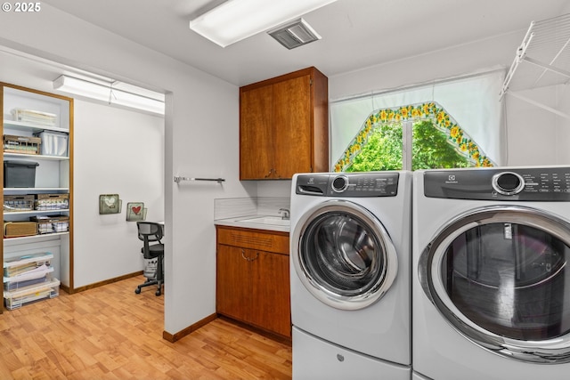 38383 Cartwright Creek Rd, Marcola, OR 97454 - laundry area with washer and clothes dryer, cabinet space, light wood-type flooring, and baseboards