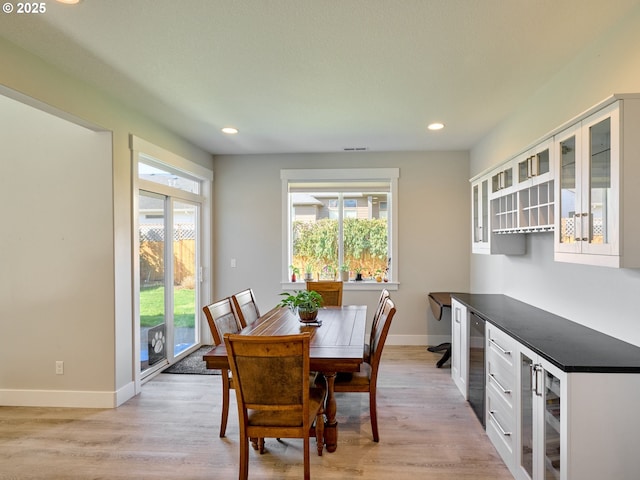 dining area with light wood-type flooring, wine cooler, baseboards, and recessed lighting