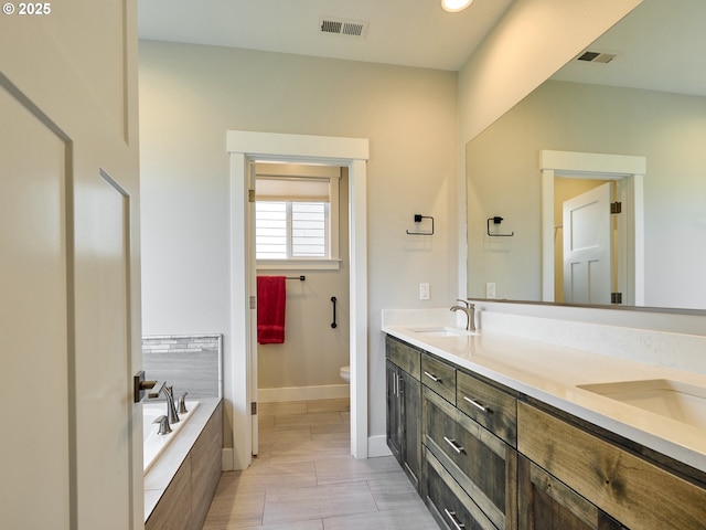 full bath featuring a garden tub, toilet, a sink, visible vents, and double vanity