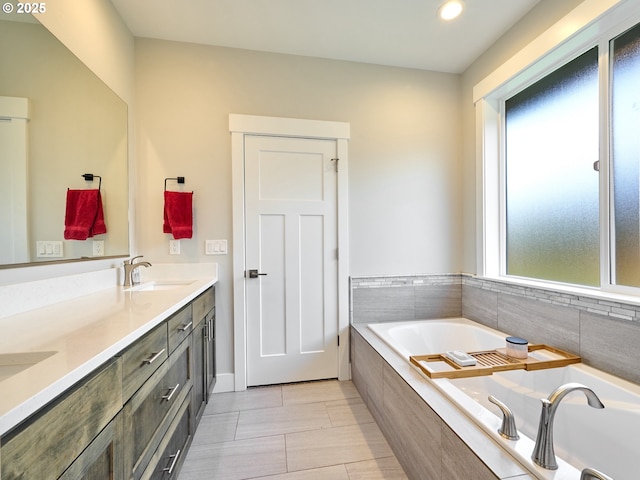 bathroom with a garden tub, a sink, and double vanity