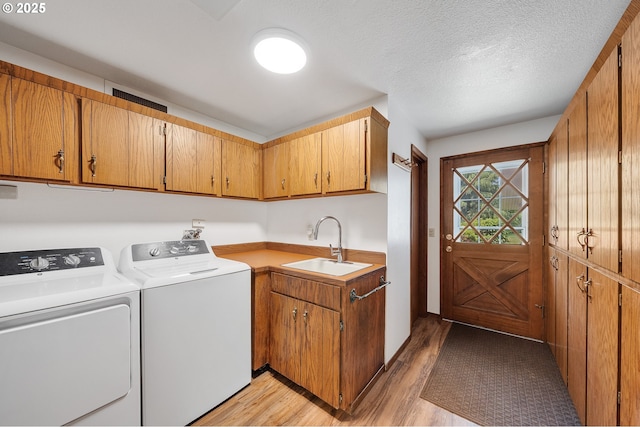 9065 Trask River Rd, Tillamook, OR 97141 - washroom featuring cabinet space, washing machine and clothes dryer, light wood-style flooring, and a textured ceiling