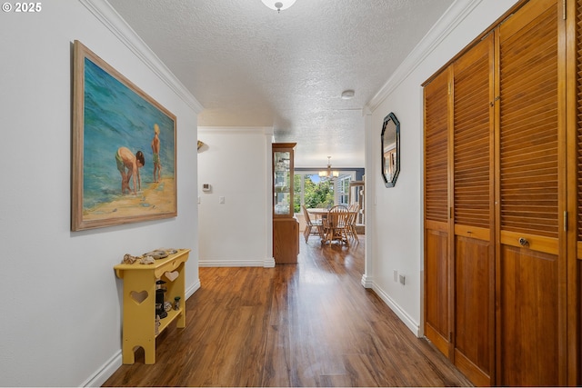 9065 Trask River Rd, Tillamook, OR 97141 - hall featuring a textured ceiling, wood finished floors, crown molding, and a chandelier
