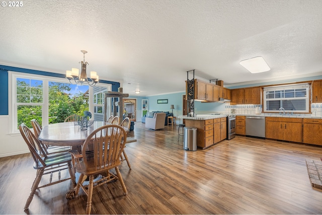9065 Trask River Rd, Tillamook, OR 97141 - dining area with a chandelier, wood finished floors, a textured ceiling, and ornamental molding