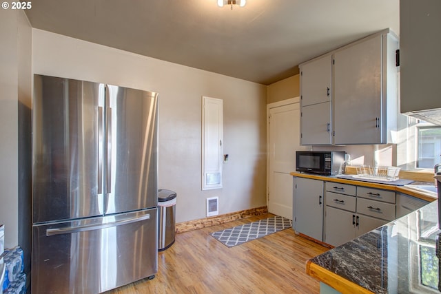 kitchen featuring light wood-type flooring, gray cabinetry, and stainless steel refrigerator