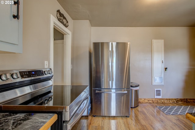 kitchen with white cabinets, appliances with stainless steel finishes, and light wood-type flooring