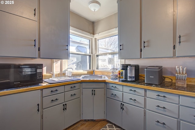 kitchen with sink, gray cabinetry, and light hardwood / wood-style flooring