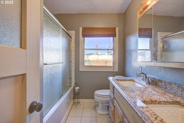 full bathroom with combined bath / shower with glass door, toilet, tile patterned floors, and vanity