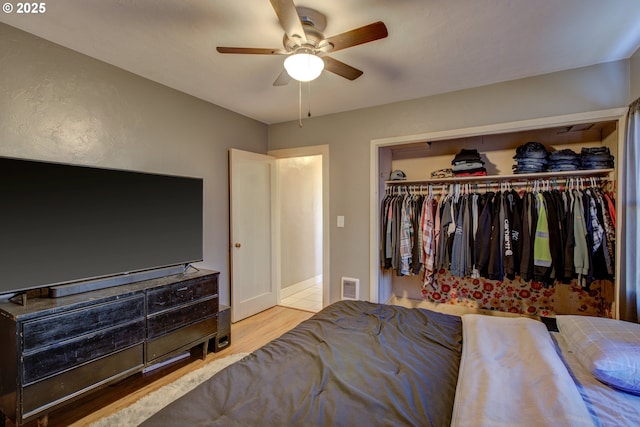 bedroom with a closet, ceiling fan, and light wood-type flooring