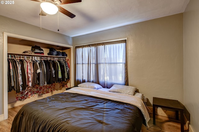 bedroom with light hardwood / wood-style flooring, a closet, and ceiling fan