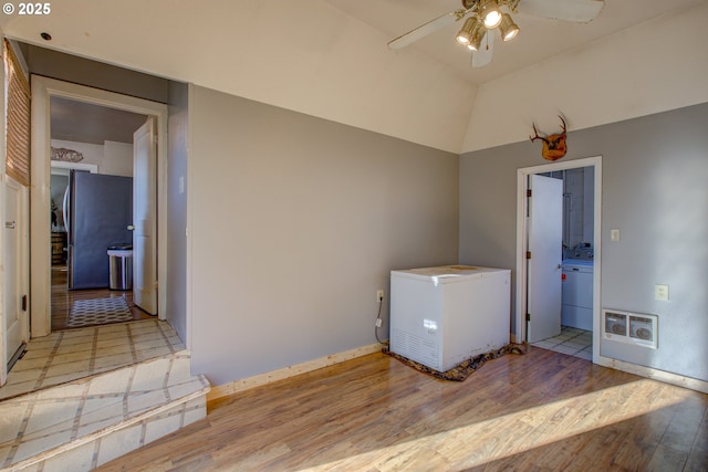 laundry area with ceiling fan and light hardwood / wood-style floors