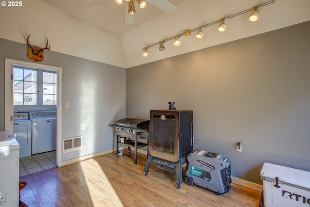 misc room featuring light wood-type flooring, vaulted ceiling, ceiling fan, and washer and dryer