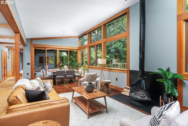 sunroom / solarium with a wood stove and lofted ceiling