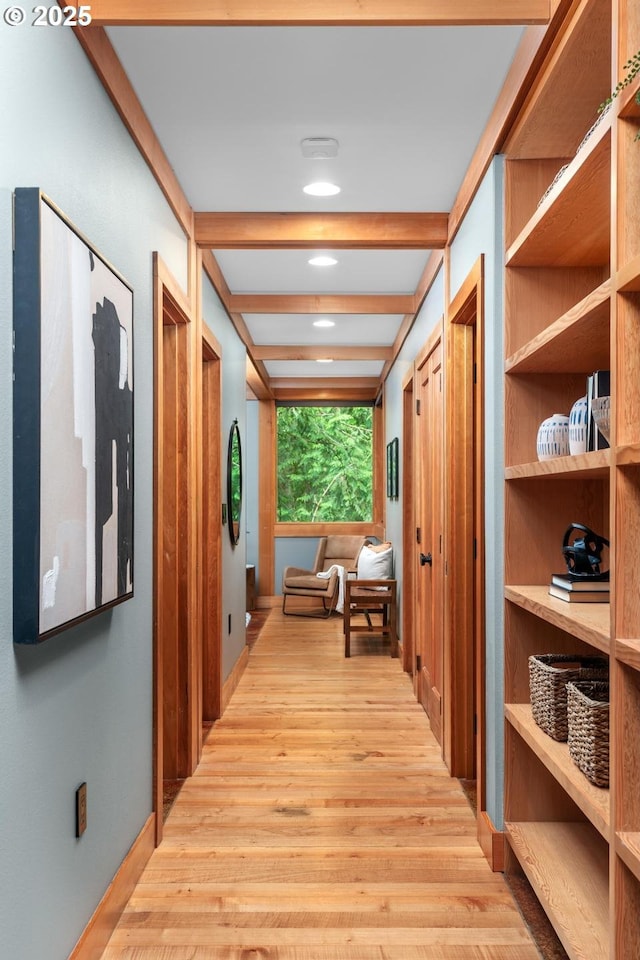 hallway featuring light wood-type flooring and beamed ceiling