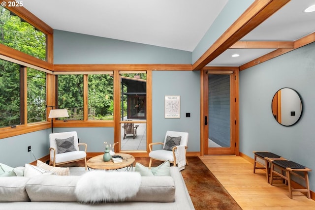 living area with wood finished floors, recessed lighting, lofted ceiling, and baseboards