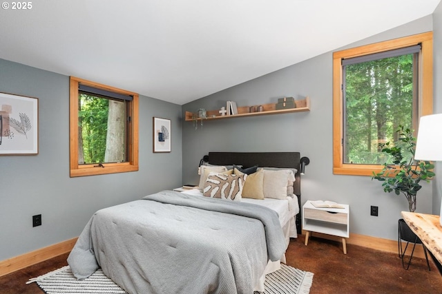 bedroom featuring lofted ceiling and baseboards
