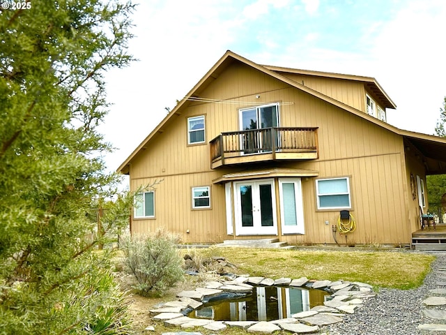 9949 Geneva View Rd, Terrebonne, OR 97760 - rear view of property featuring french doors, a balcony, a small pond, and entry steps