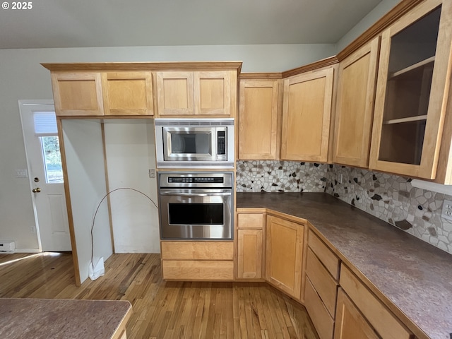 9949 Geneva View Rd, Terrebonne, OR 97760 - kitchen with appliances with stainless steel finishes, light wood-type flooring, dark countertops, and tasteful backsplash