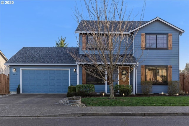 traditional-style home featuring a shingled roof, a front lawn, fence, a garage, and driveway