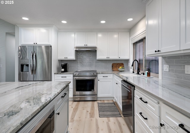 10262 SE 99th Dr, Happy Valley, OR 97086 - kitchen with appliances with stainless steel finishes, under cabinet range hood, a sink, light wood-style flooring, and white cabinets