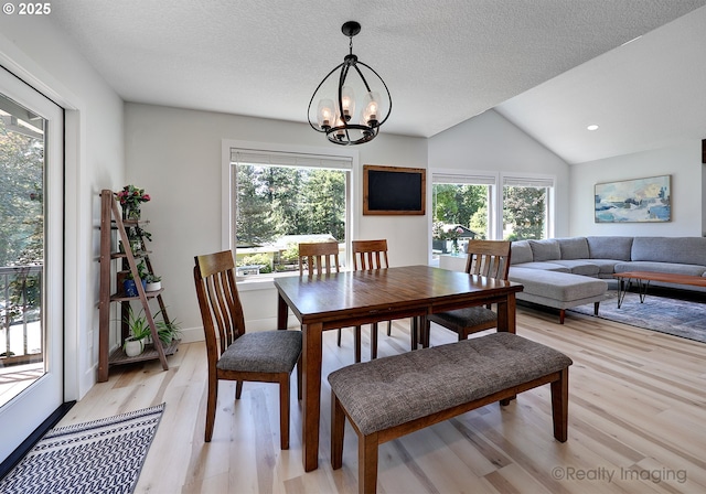 10262 SE 99th Dr, Happy Valley, OR 97086 - dining area featuring light wood-style flooring, a chandelier, lofted ceiling, and a textured ceiling