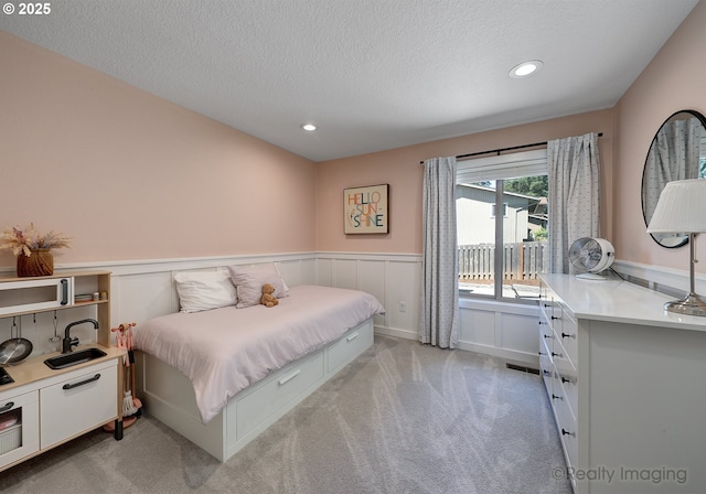 10262 SE 99th Dr, Happy Valley, OR 97086 - bedroom with light colored carpet, a wainscoted wall, a textured ceiling, recessed lighting, and a decorative wall