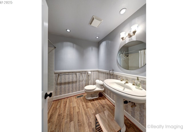 10262 SE 99th Dr, Happy Valley, OR 97086 - full bathroom featuring toilet, wood finished floors, a shower with curtain, a wainscoted wall, and recessed lighting