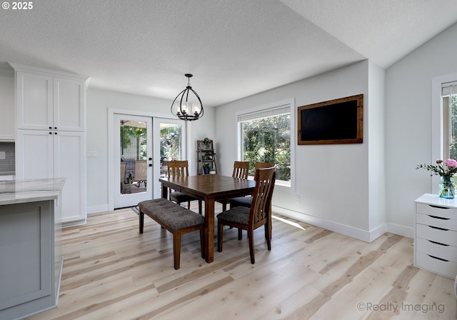 10262 SE 99th Dr, Happy Valley, OR 97086 - dining space featuring light wood-type flooring, a chandelier, baseboards, a textured ceiling, and french doors