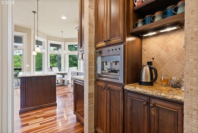 4640 SE Honors Dr, Gresham, OR 97080 - kitchen featuring light wood-type flooring, pendant lighting, light stone counters, recessed lighting, and open shelves