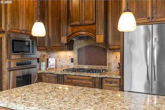 4640 SE Honors Dr, Gresham, OR 97080 - kitchen featuring stainless steel appliances, tasteful backsplash, light stone counters, and hanging light fixtures