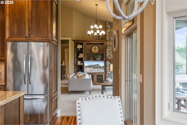 4640 SE Honors Dr, Gresham, OR 97080 - kitchen featuring freestanding refrigerator, a chandelier, lofted ceiling, light stone countertops, and hanging light fixtures