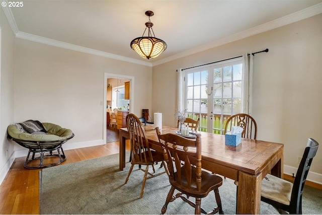 dining room with wood-type flooring, crown molding, and french doors