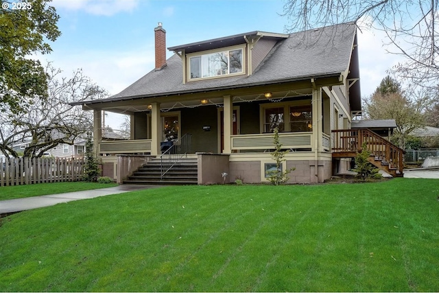 view of front facade with a front yard and covered porch