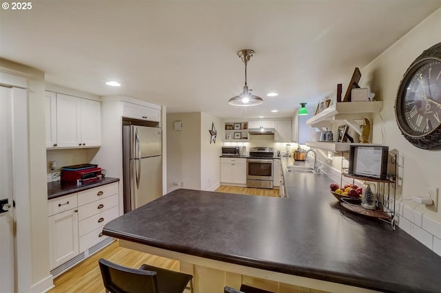 kitchen featuring sink, appliances with stainless steel finishes, white cabinetry, hanging light fixtures, and kitchen peninsula