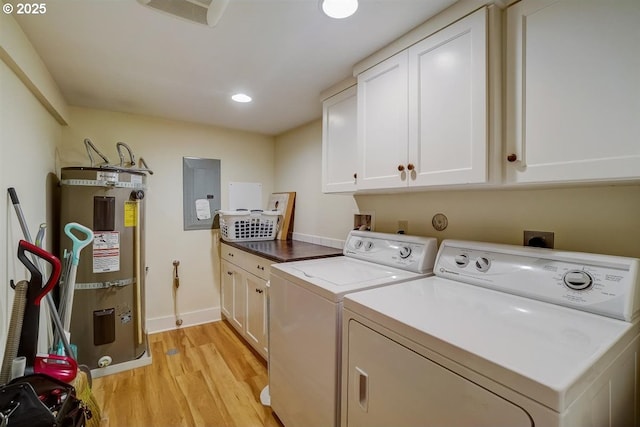 laundry area featuring washer and dryer, strapped water heater, cabinets, electric panel, and light hardwood / wood-style floors