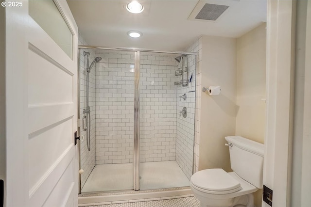 bathroom with a shower with door and toilet