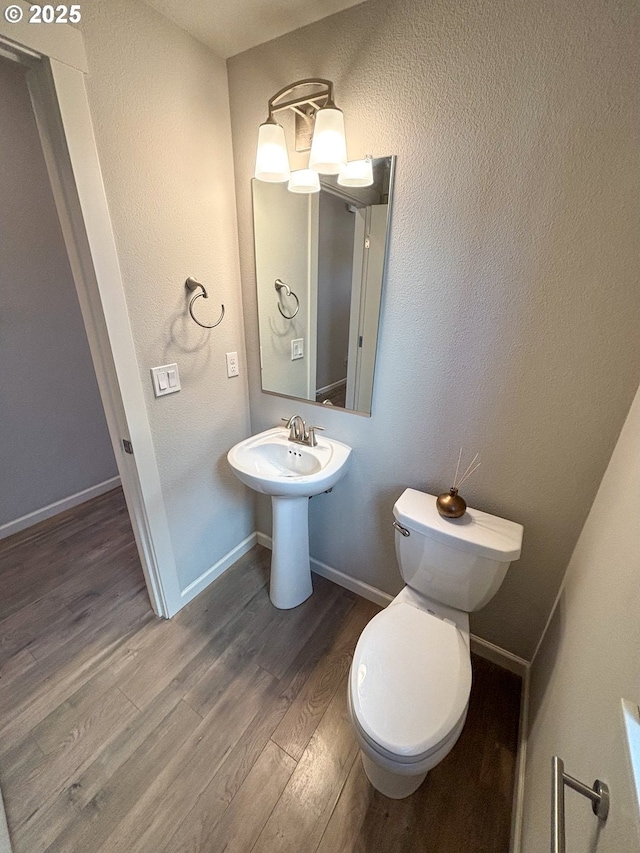 bathroom with hardwood / wood-style floors and toilet