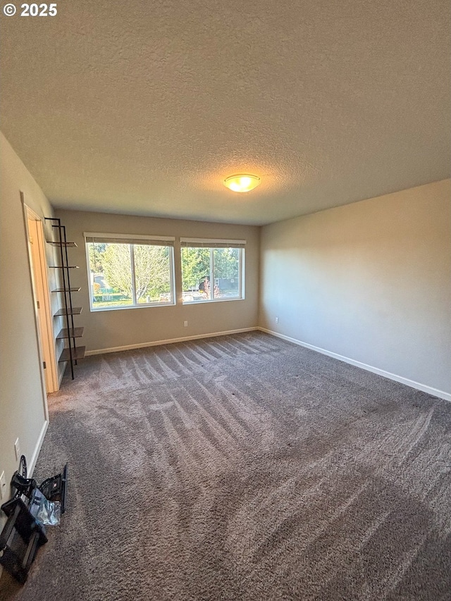 carpeted empty room featuring a textured ceiling