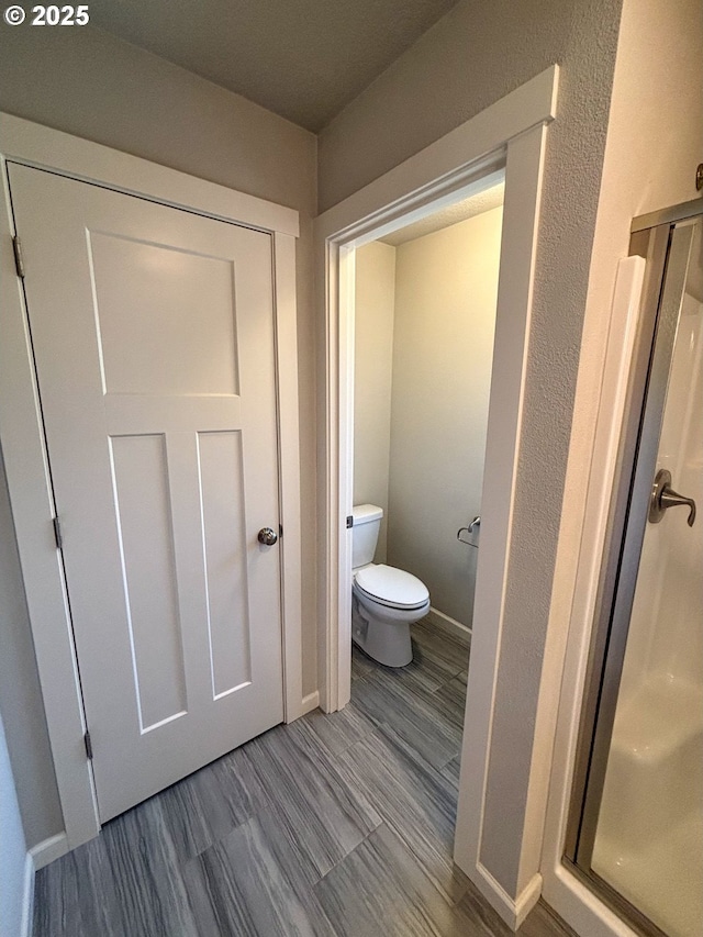 bathroom with hardwood / wood-style flooring and toilet