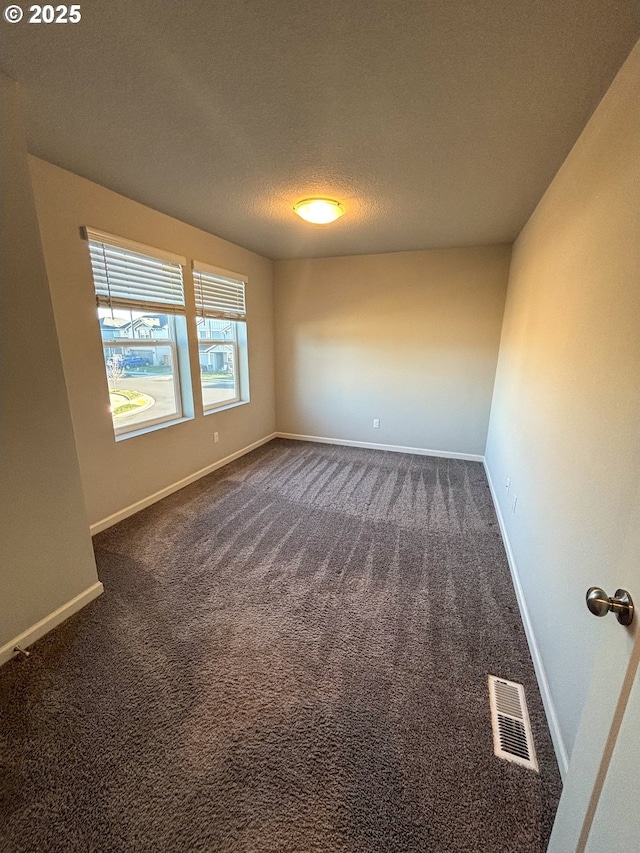 carpeted spare room featuring a textured ceiling