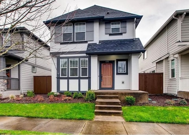 view of front of property featuring a shingled roof, fence, and stucco siding