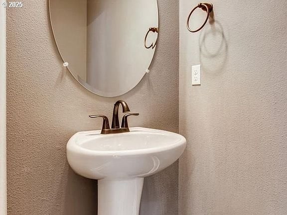 bathroom with a textured wall and a sink