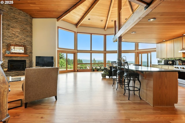 38617 SE Nichols Hill Rd, Washougal, WA 98671 - kitchen featuring a wood ceiling with exposed beams, white range, a breakfast bar area, light wood-style floors, and high vaulted ceiling