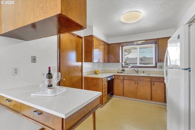 861 Dietz Ave NE, Keizer, OR 97303 - kitchen with freestanding refrigerator, a textured ceiling, dishwasher, brown cabinets, and light countertops