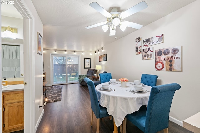 dining room with dark wood-type flooring, ceiling fan, and a textured ceiling