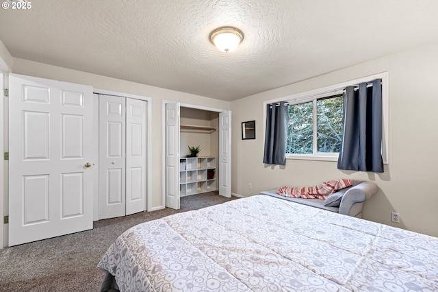 carpeted bedroom featuring a textured ceiling and two closets