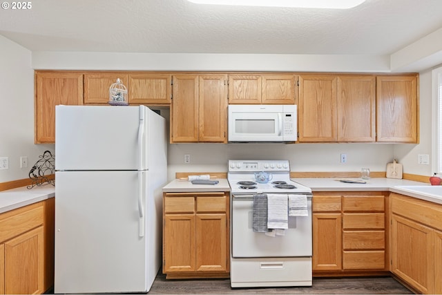 kitchen featuring white appliances, dark hardwood / wood-style floors, and a textured ceiling